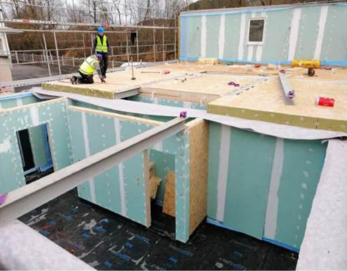 Montáž nízkoenergetického montovaného drevodomu – stavba z&nbsp;drevených panelov s tepelnou izoláciou počas výstavby na&nbsp;kľúč.